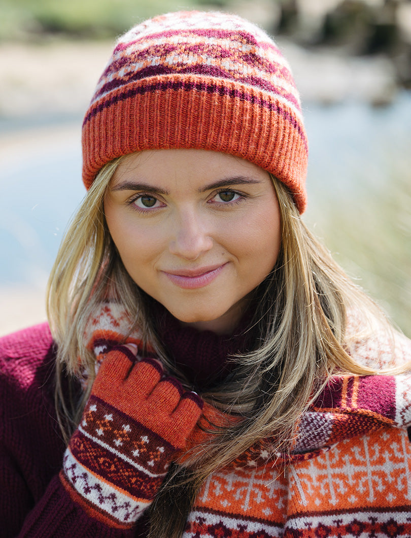 Girl wearing orange and burgundy fair isle beanie hat